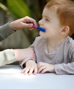 jongen oefent met tongue depressor tip